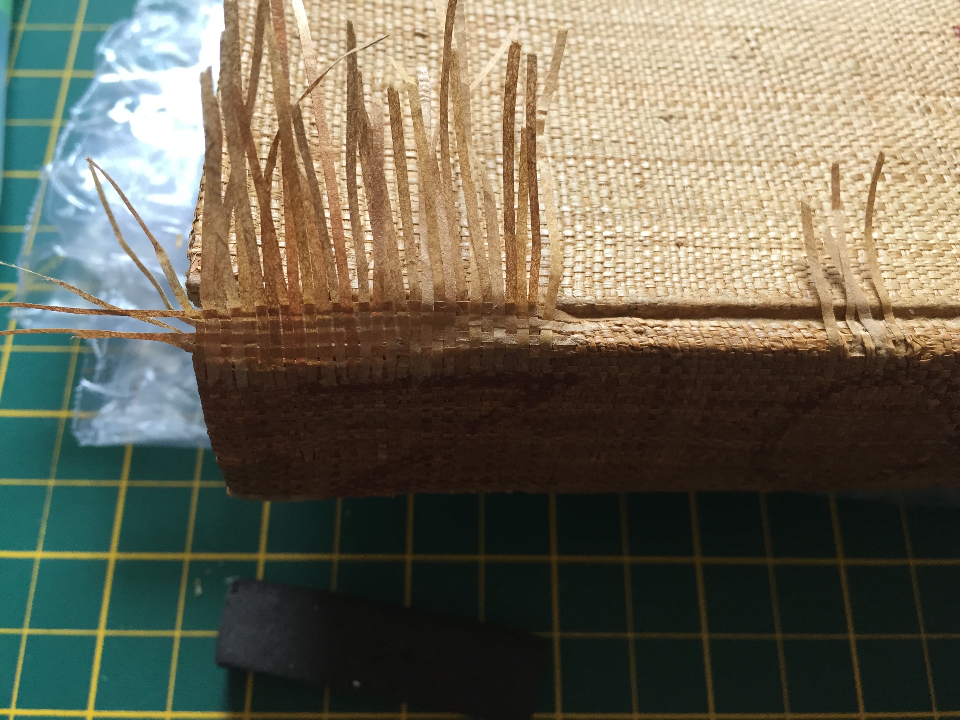 The woven infill of Japanese paper sits along the spine with the far ends left long before being stuck down.